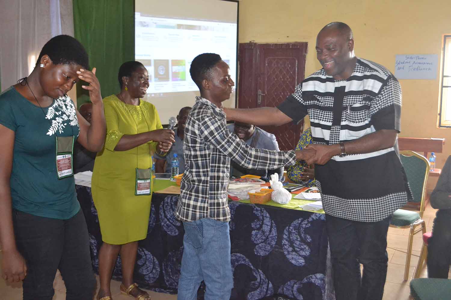 Winners of the Poetry workshop prizes in a hand shake with the Vice Chancellor